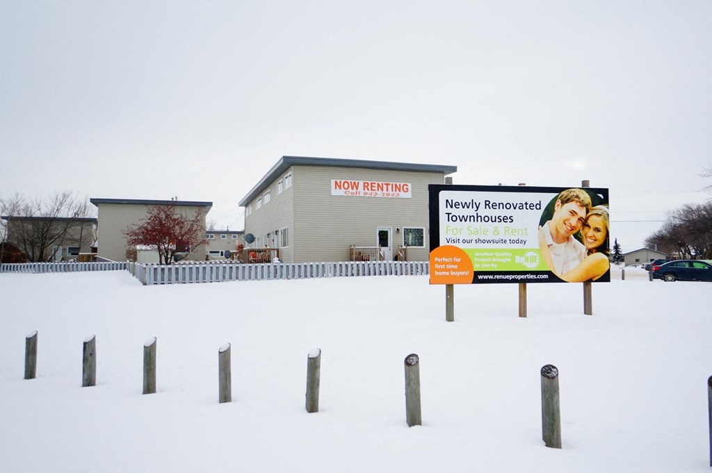 a sign in the snow in front of a building