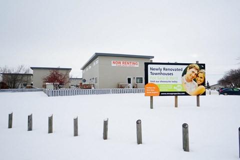 a sign in the snow in front of a building