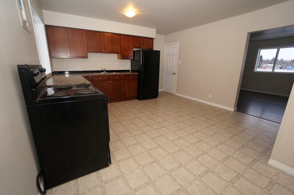 an empty kitchen with a stove and a refrigerator