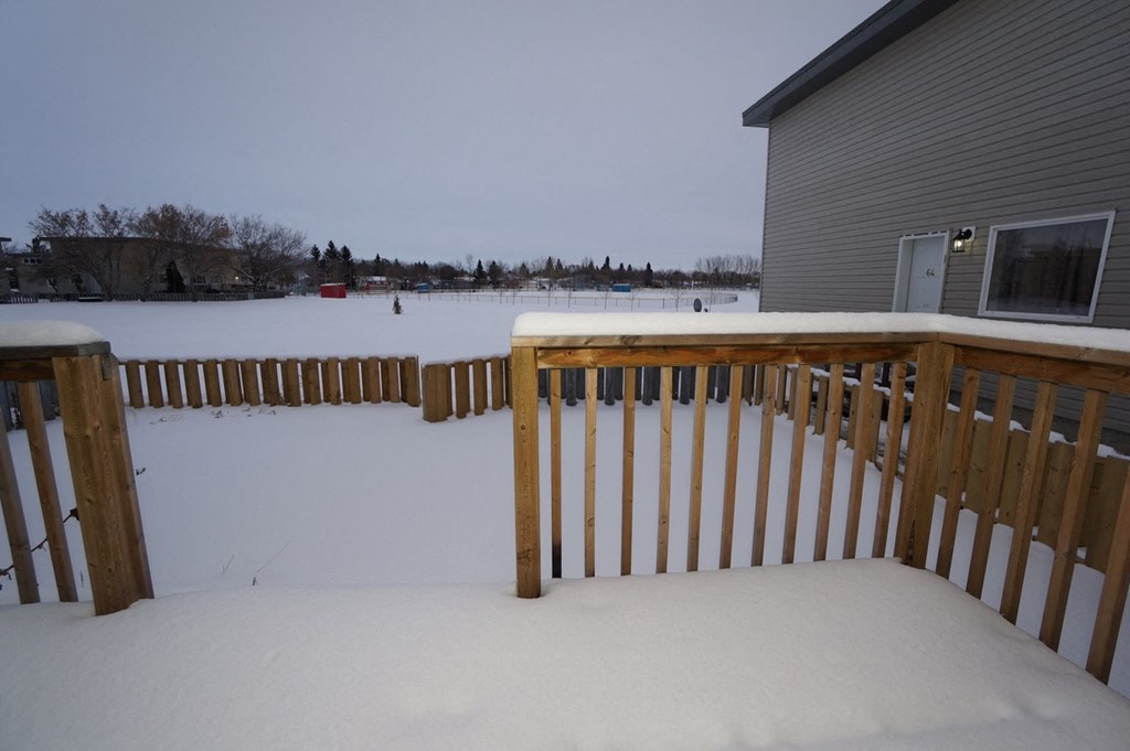 a deck covered in snow next to a house