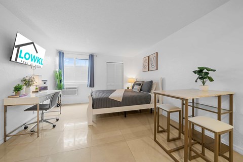 a bedroom with a bed and a desk and a table with chairs