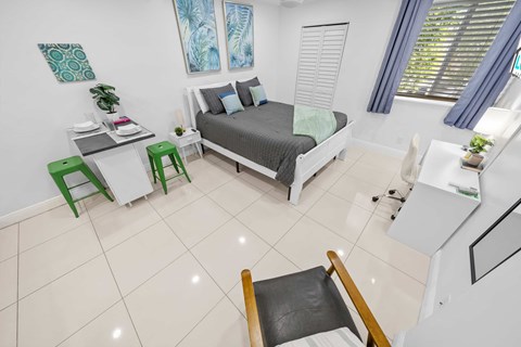 a bedroom with a bed and a desk in a small room