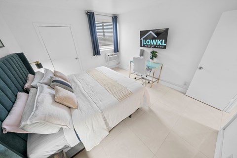 a bedroom with a bed and a chair and a desk