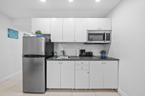 a kitchen with white cabinets and a stainless steel refrigerator
