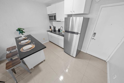 a kitchen with a table and a refrigerator