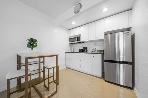 a kitchen with a table and a refrigerator