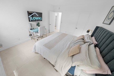 a white bedroom with a bed and a couch