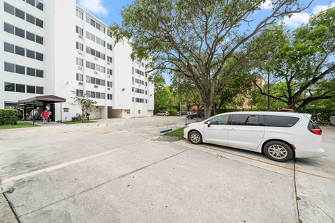 a white van parked in a parking lot in front of a building