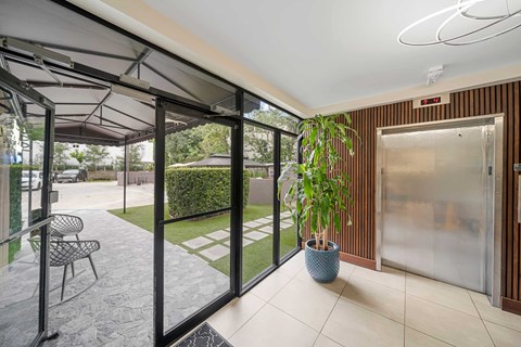 a patio with glass doors and a potted plant