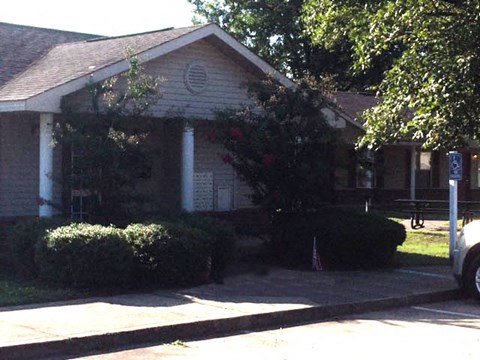 a small white house with a tree in front of it