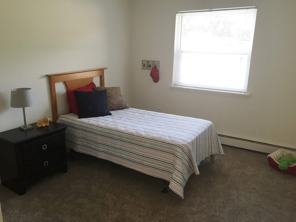 a small bedroom with a bed and a window