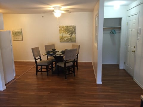 a dining room with a table and chairs and a hallway with a door and a