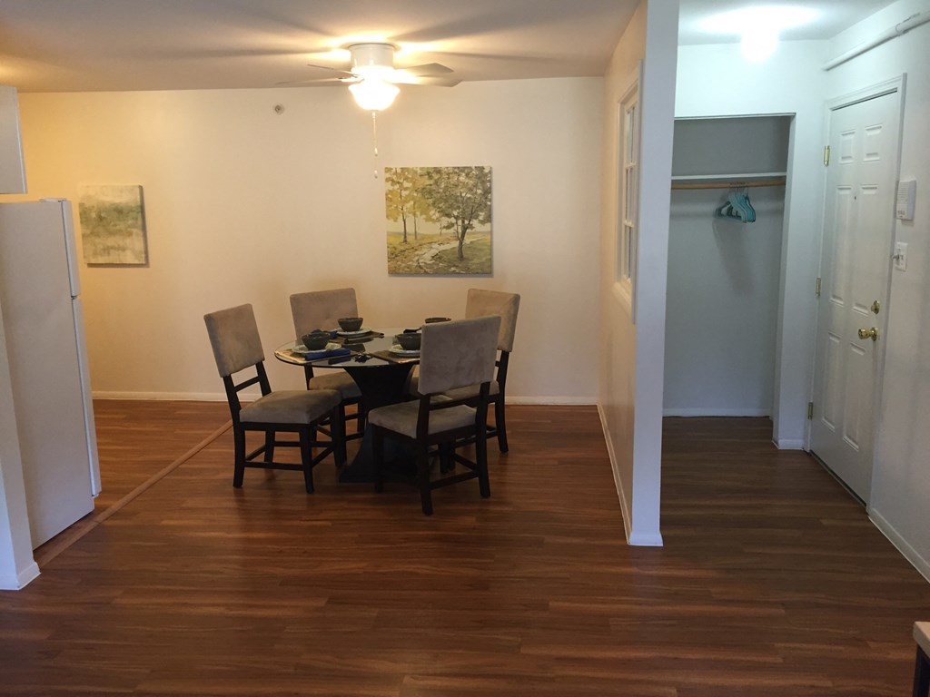 a dining room with a table and chairs and a hallway with a door and a