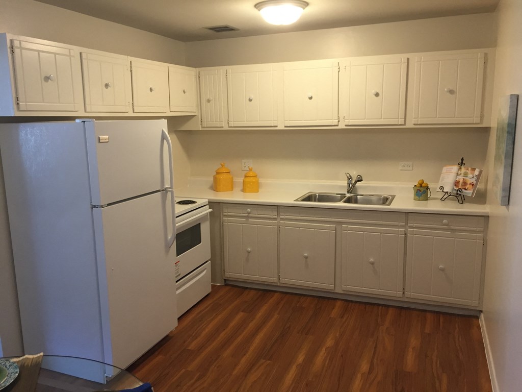 a kitchen with white cabinets and a refrigerator