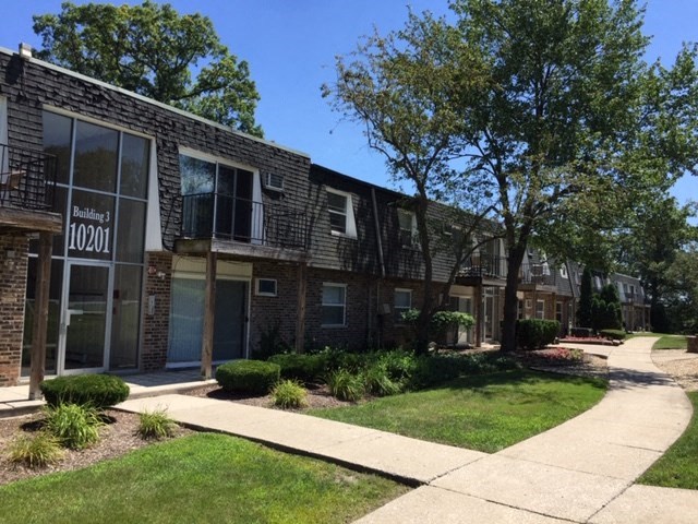 a brick building with a sidewalk in front of it