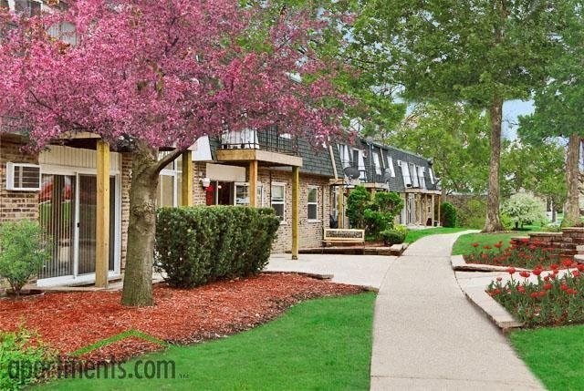 a house with a flowering tree and a sidewalk