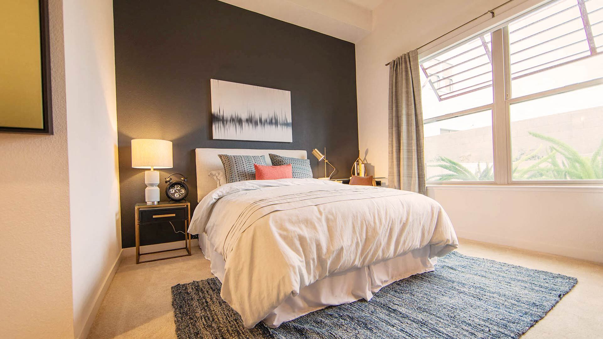 a bedroom with a bed and a large window