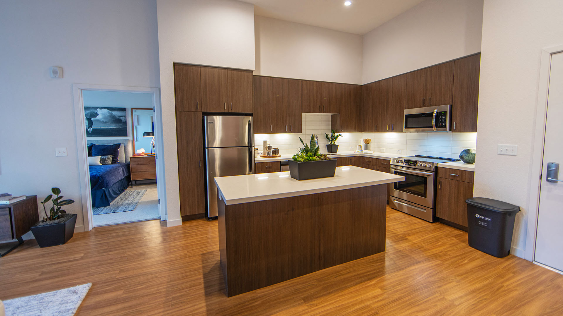 a kitchen with a large island and a stainless steel refrigerator