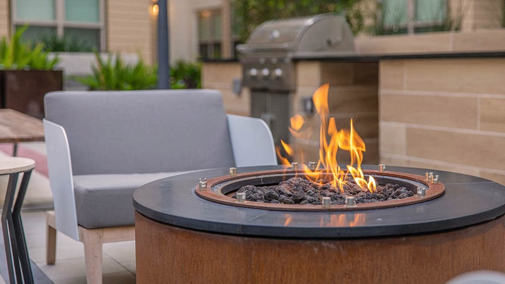 a fire pit on a patio with chairs around it