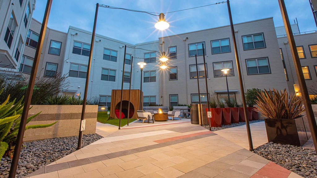 a courtyard with a fire pit in front of an apartment building
