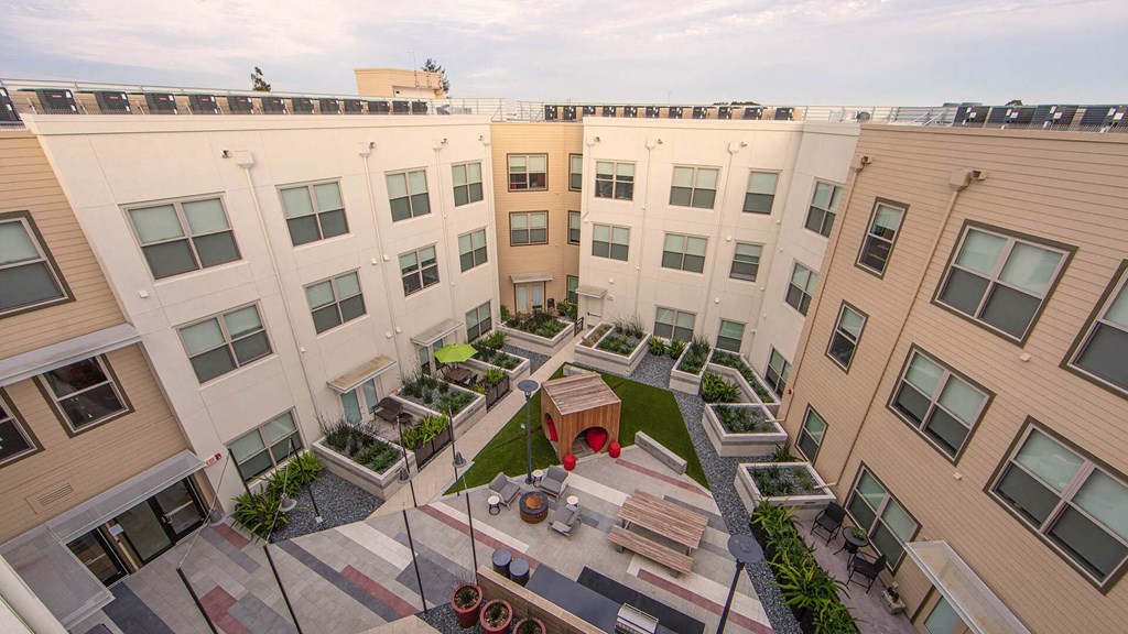 an aerial view of the courtyard of a building with a table and benches