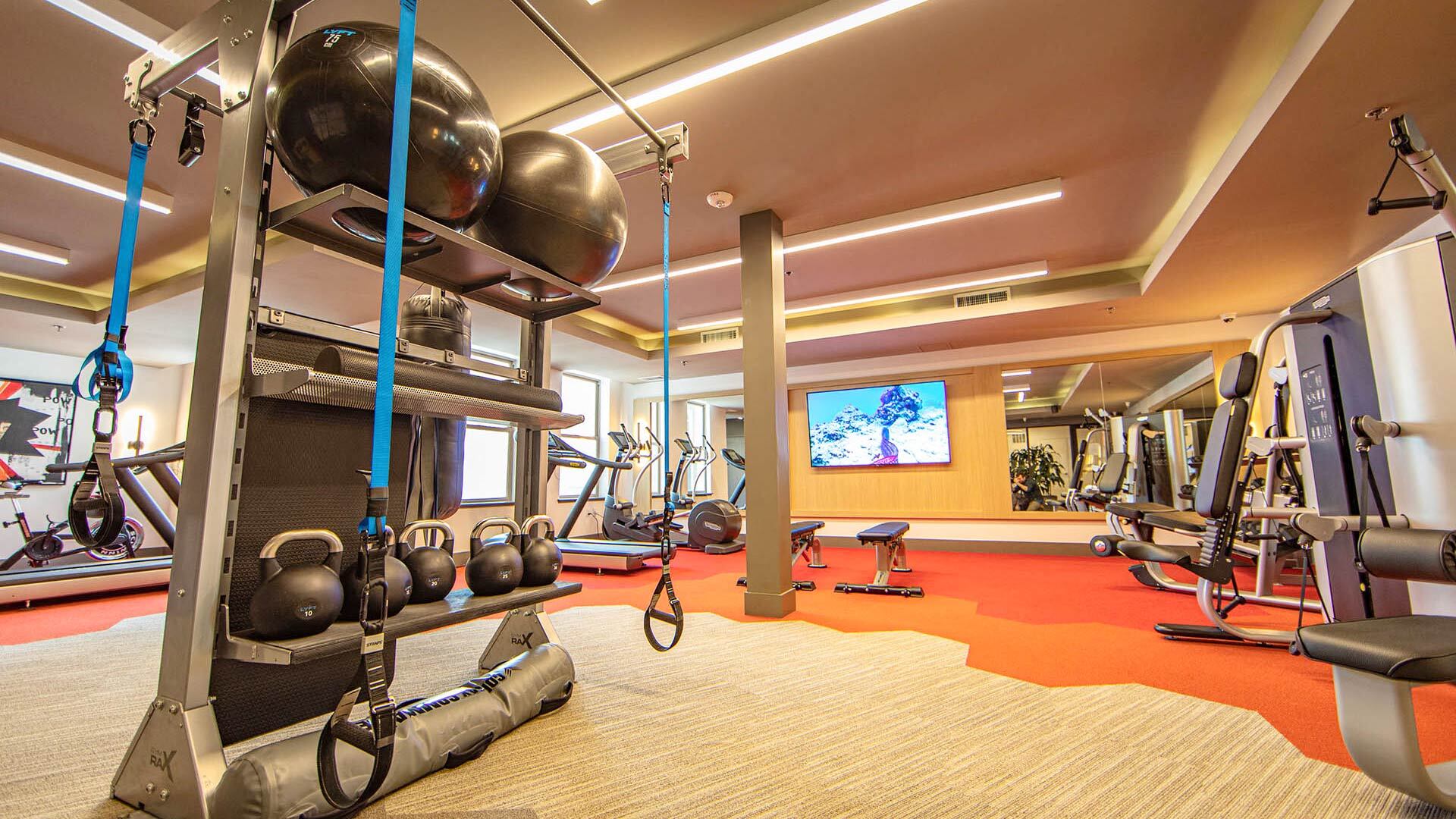 a gym with weights and other exercise equipment in a hotel room