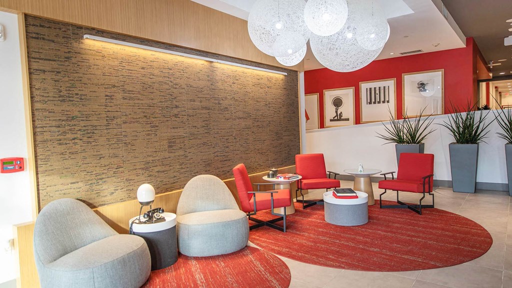 a lounge area with chairs and tables and a wall