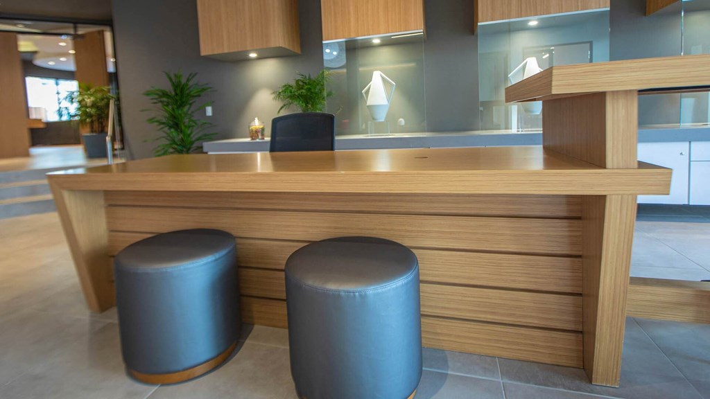 a reception desk in a office with two stools
