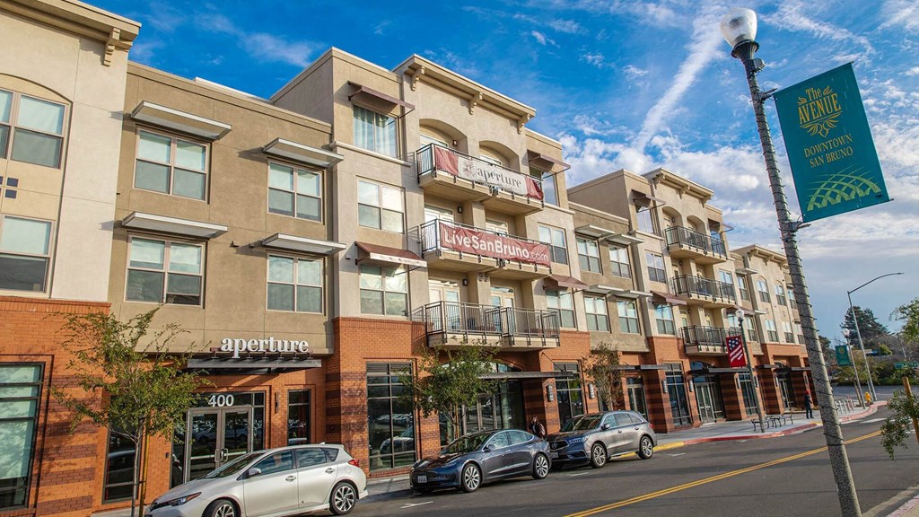 a street view of a building with cars parked in front of it