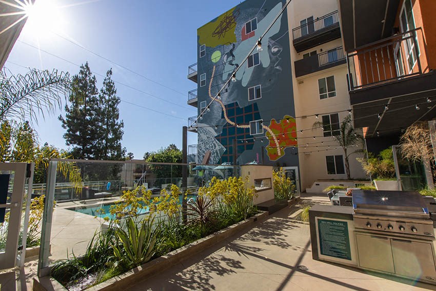 a mural on the side of a building next to a swimming pool