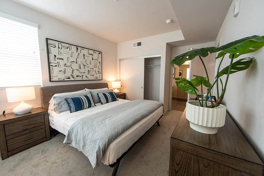 a bedroom with a bed and a potted plant