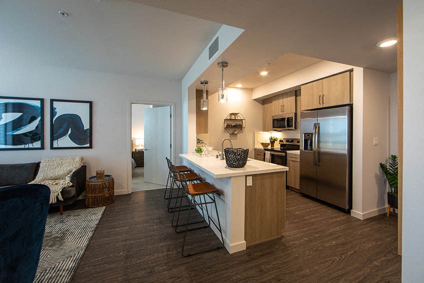 a kitchen with a bar and a stainless steel refrigerator