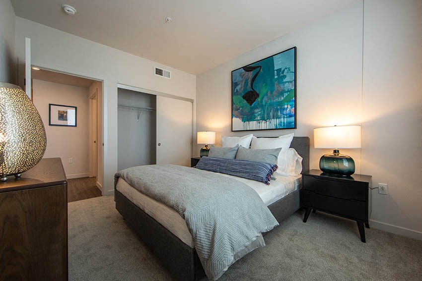 a bedroom with a bed and a painting on the wall