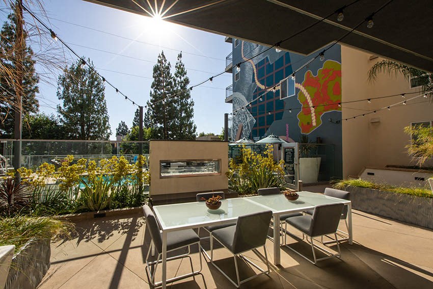 a patio with a table and chairs and a fireplace