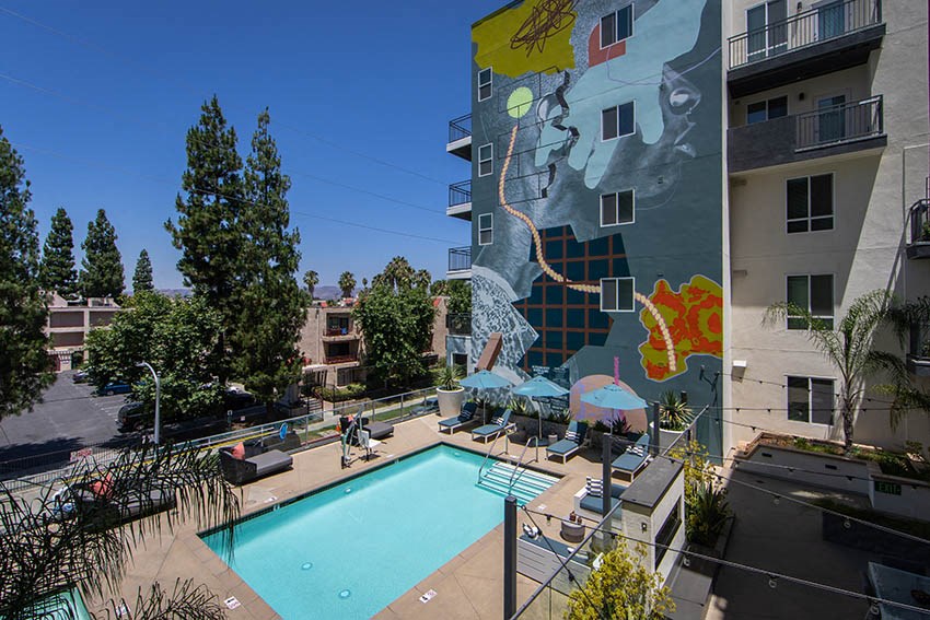 a pool with a mural on the side of a building