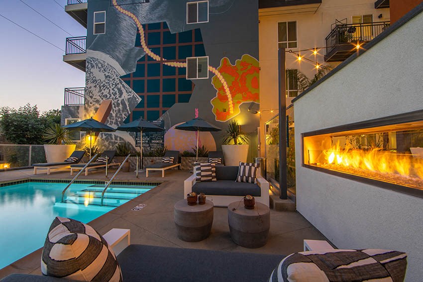 the pool area of a hotel with a fireplace and a swimming pool