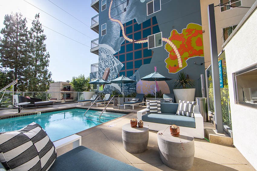 a swimming pool with a mural on the side of a building