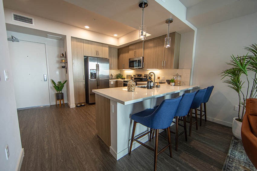 a kitchen with a bar and blue chairs