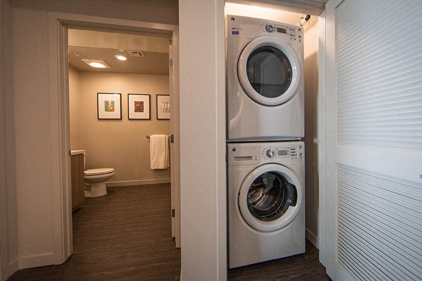 a bathroom with a washing machine and a toilet