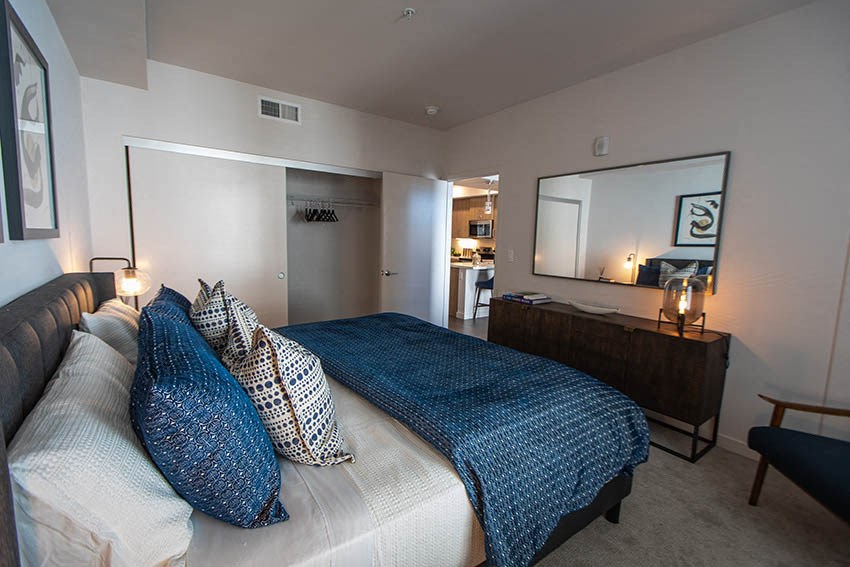 a bedroom with a bed and a dresser and a mirror