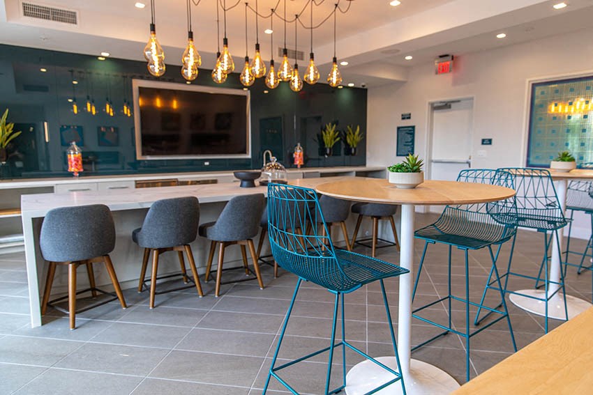 a kitchen with a bar and chairs and a table