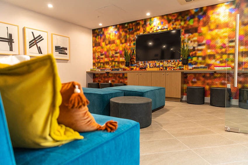 the lobby of a hotel with a stuffed animal on a blue couch