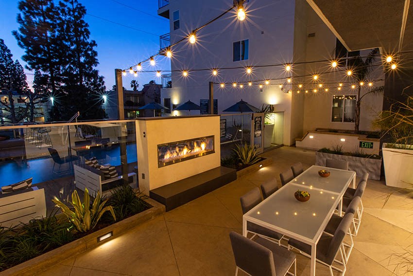a patio with a table and chairs and a fireplace