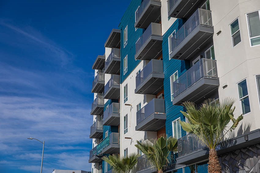 a tall building with palm trees in front of it
