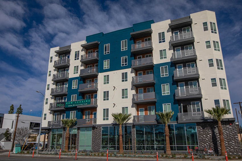 a new apartment building with palm trees in front of it