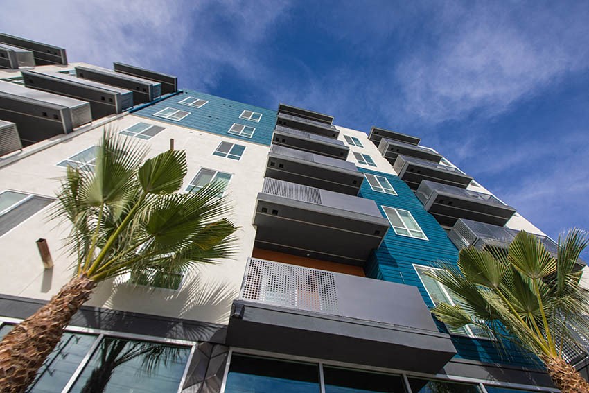 a tall building with palm trees in front of it