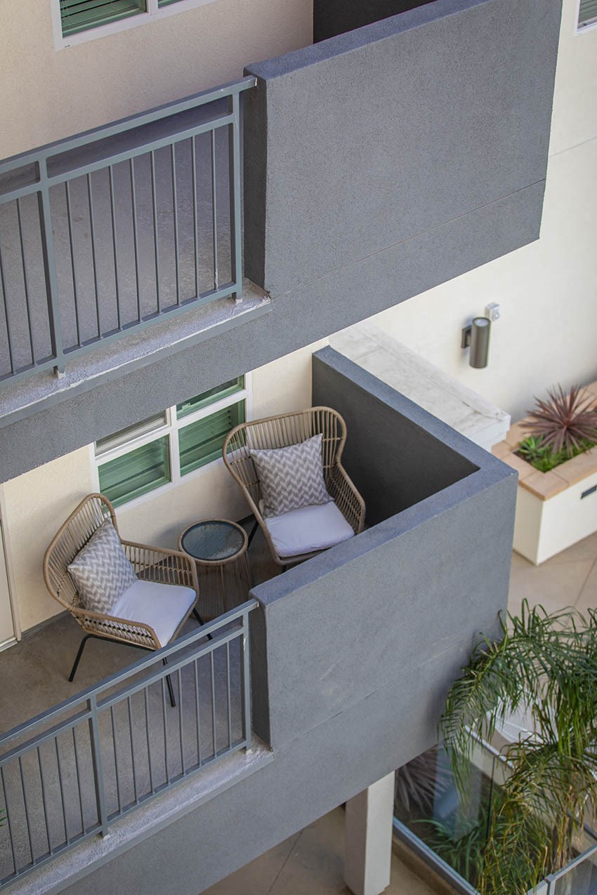 a balcony with chairs and a table