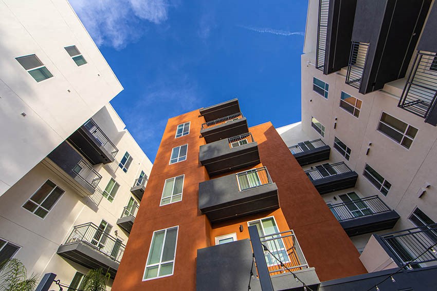 a group of apartment buildings with a blue sky in the background