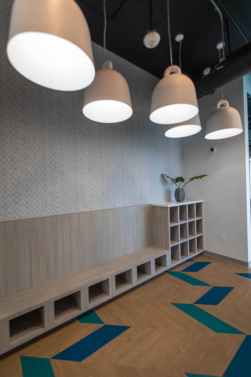 a room with a long bench and lights on the ceiling