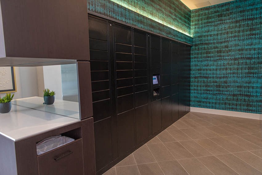 a large closet with black cabinets and a mirror